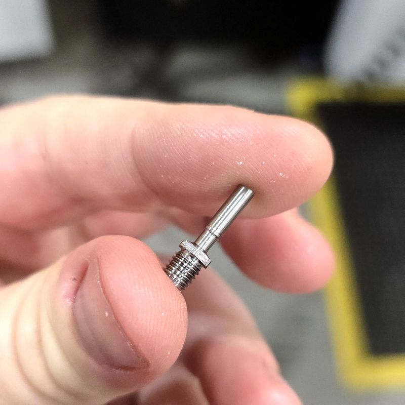 Swiss-turned titanium heatbreak held between two fingers